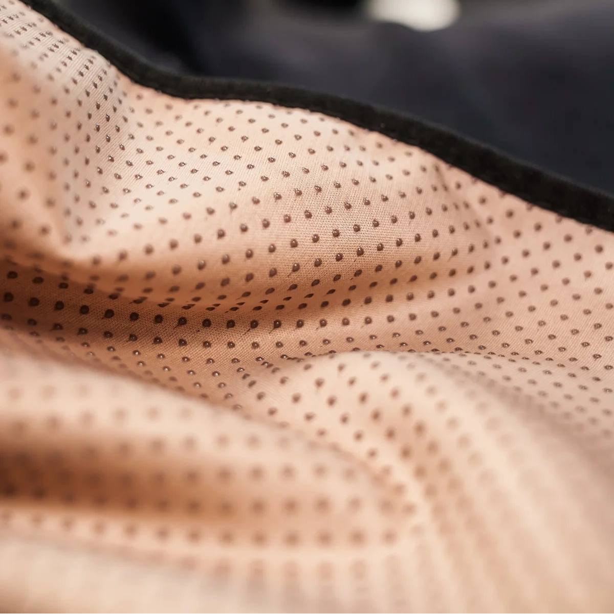 Close-up of beige textured fabric with black border